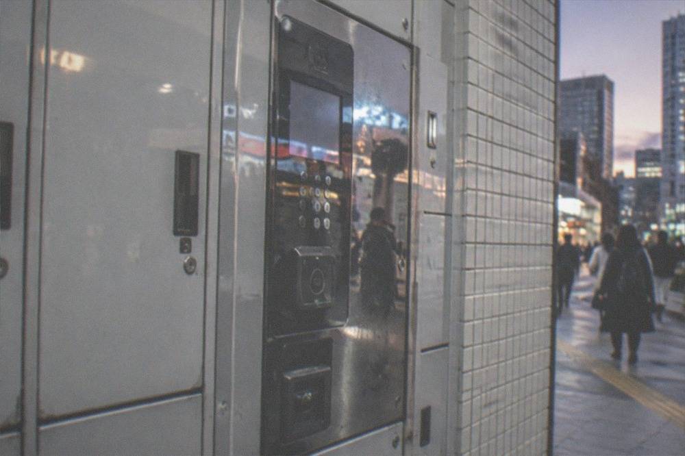 a coin locker keypad and card reader panel on a Tokyo station wall