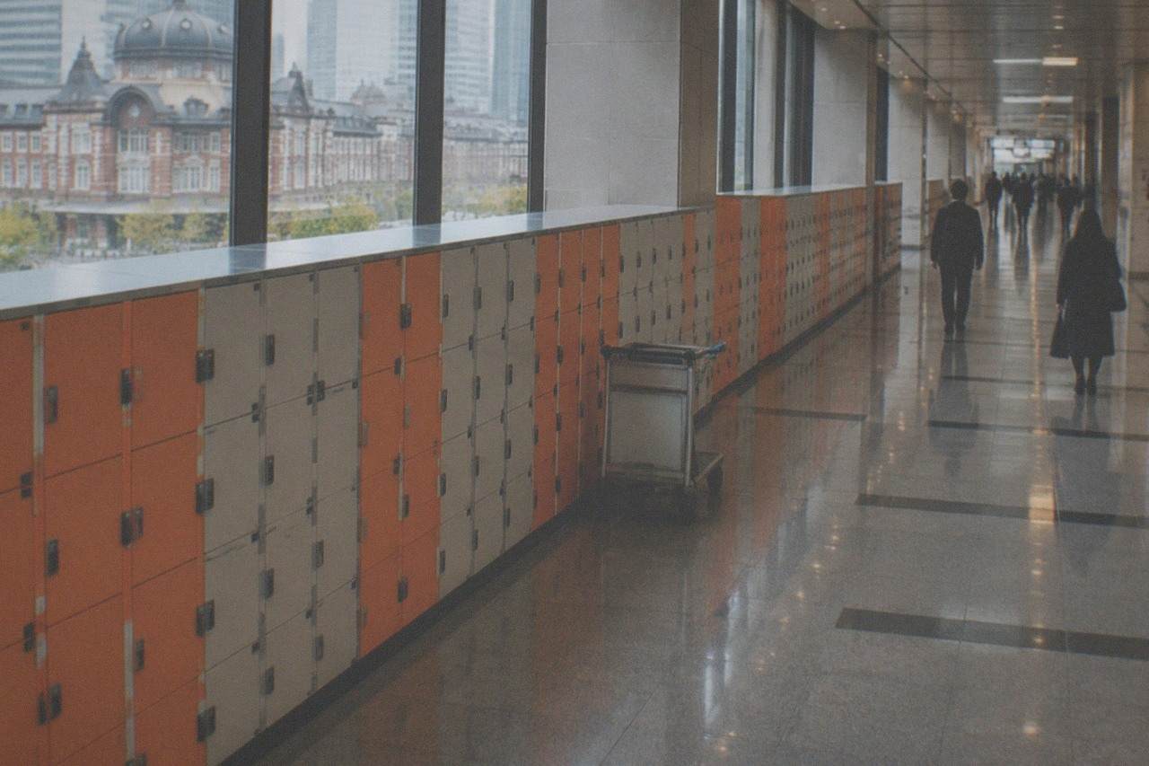 Rows of orange and grey coin lockers along a station corridor wall in Tokyo