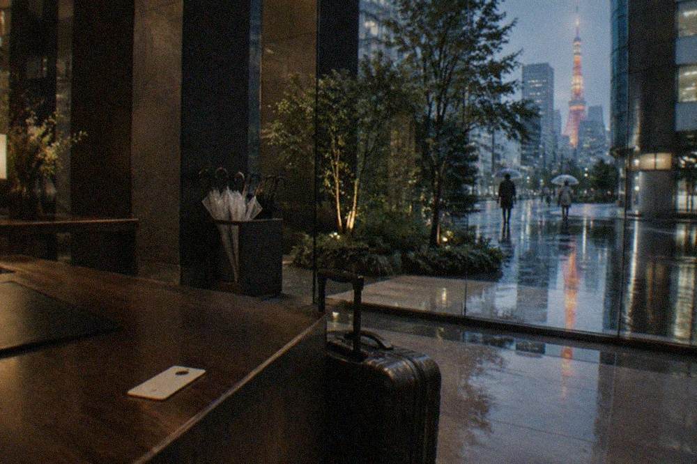 A hotel front desk counter with a suitcase beside it and a small numbered claim ticket on the counter