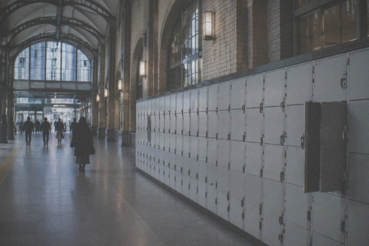 A wide hallway in a Japanese rail station with a long row of coin lockers along one wall