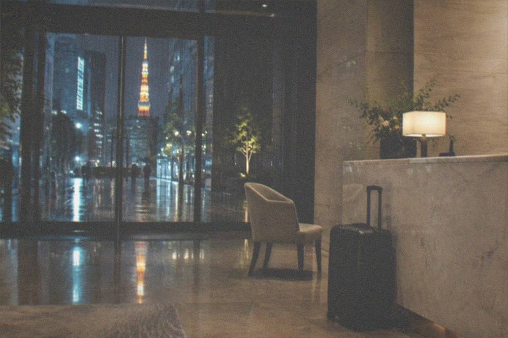 A suitcase parked beside a hotel front desk counter in an empty lobby