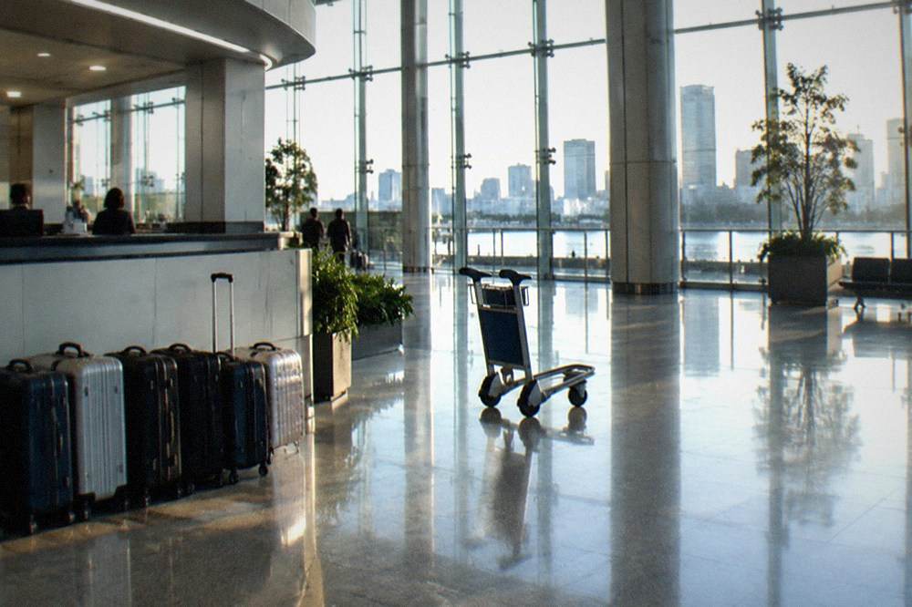 An airport arrival hall counter with suitcases lined beside it