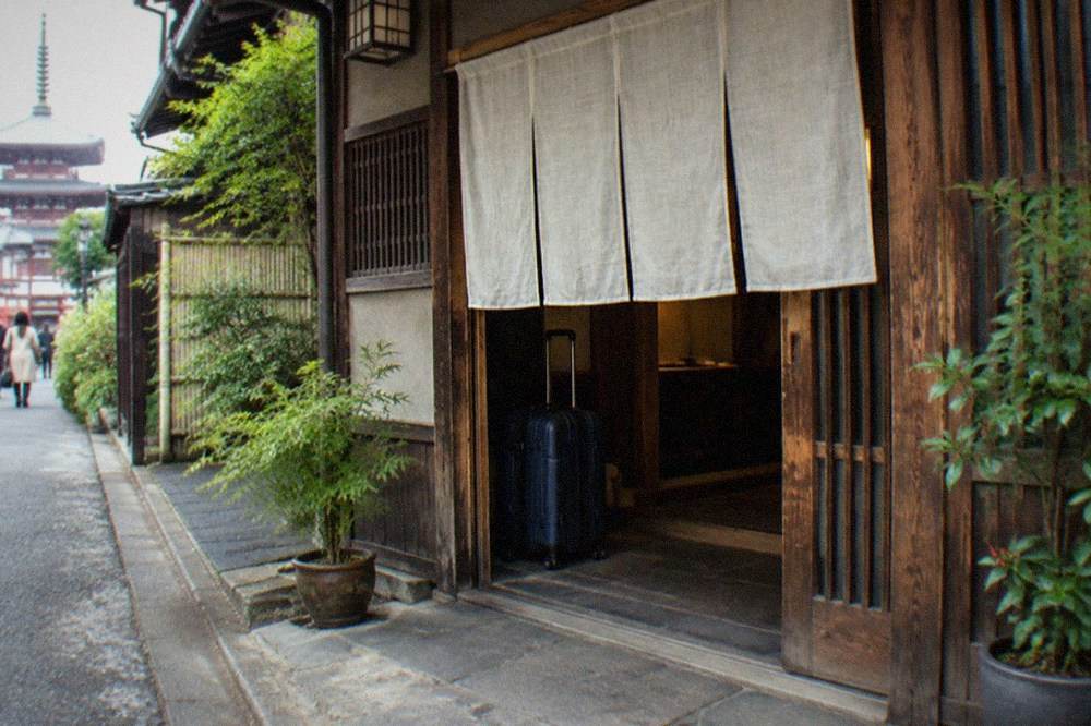 A shop entrance in an older Tokyo neighbourhood with a luggage storage sign on the door
