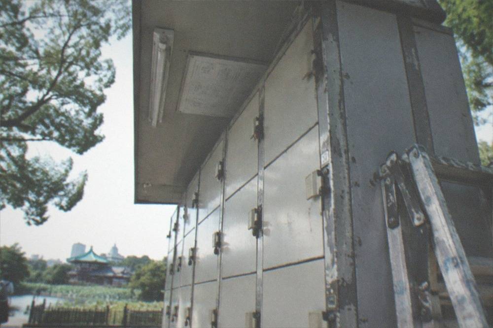 Sign explaining coin locker terms above a row of lockers in Japanese and English