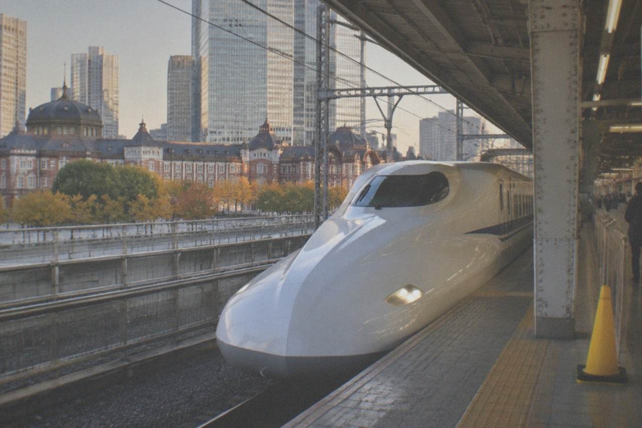 A bullet train at a platform in Tokyo Station with the departure board above
