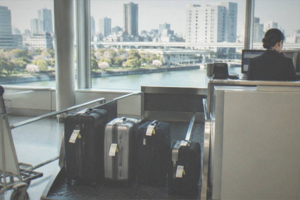 The attended baggage storage counter at Haneda Airport Terminal 3 with a staff member behind the desk