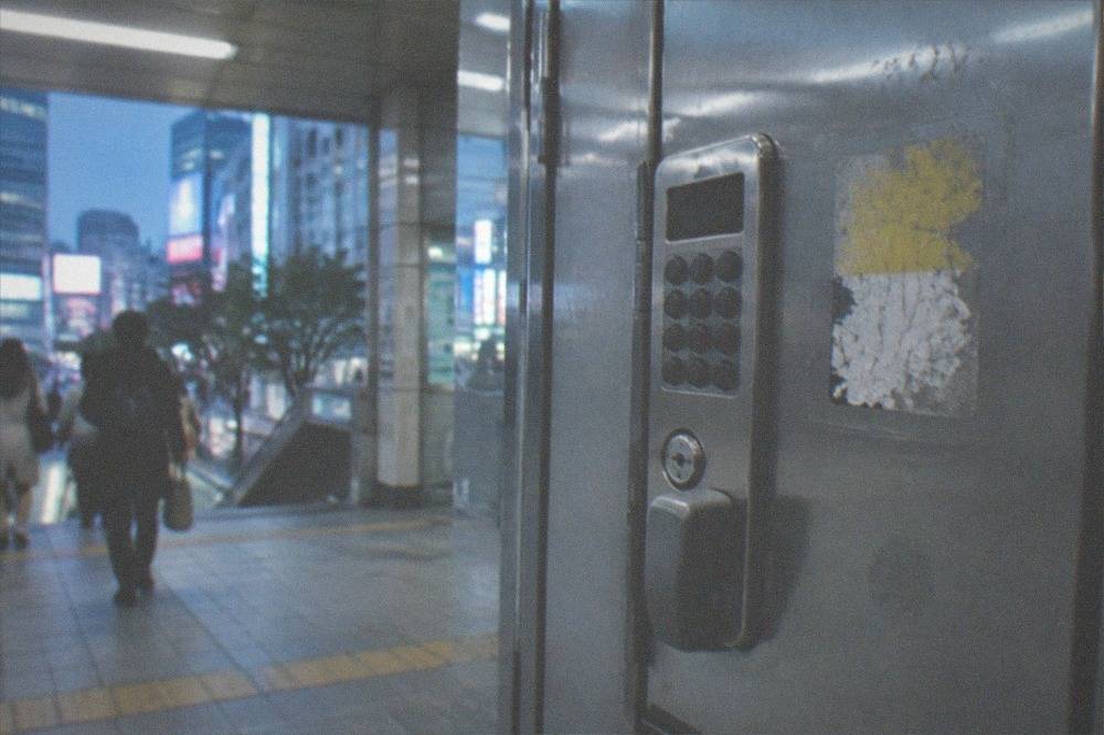 Close view of a coin locker keypad and price sticker in a Tokyo station, no people.