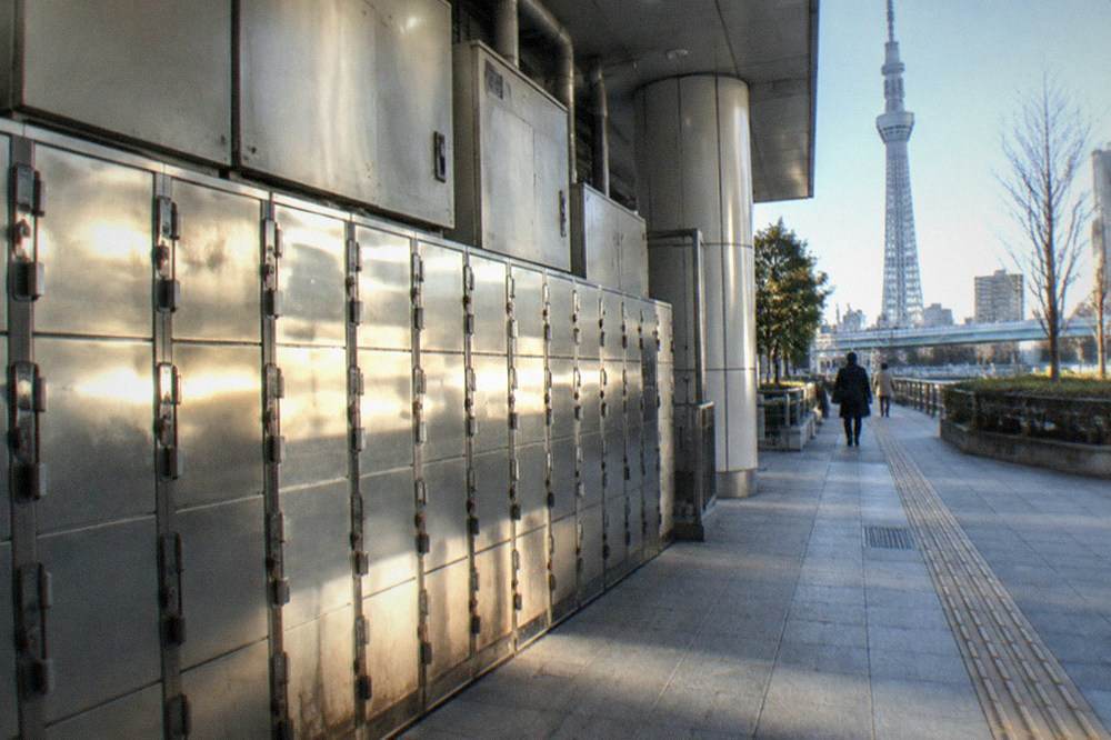 Close view of coin locker doors in a Tokyo subway station, showing a mix of large and small locker sizes